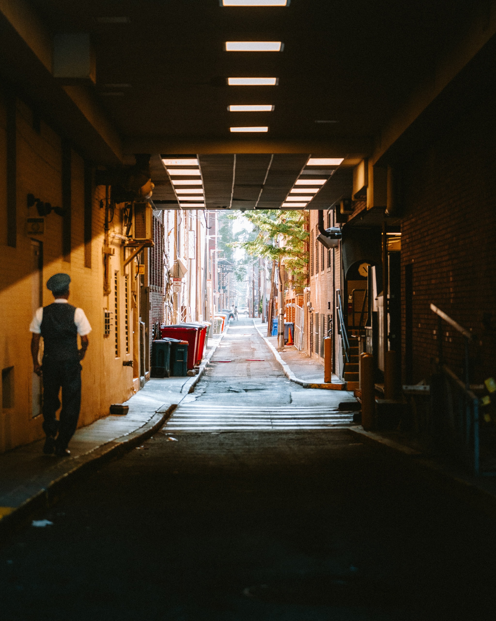 A figure silhouetted at the end of a dark alley