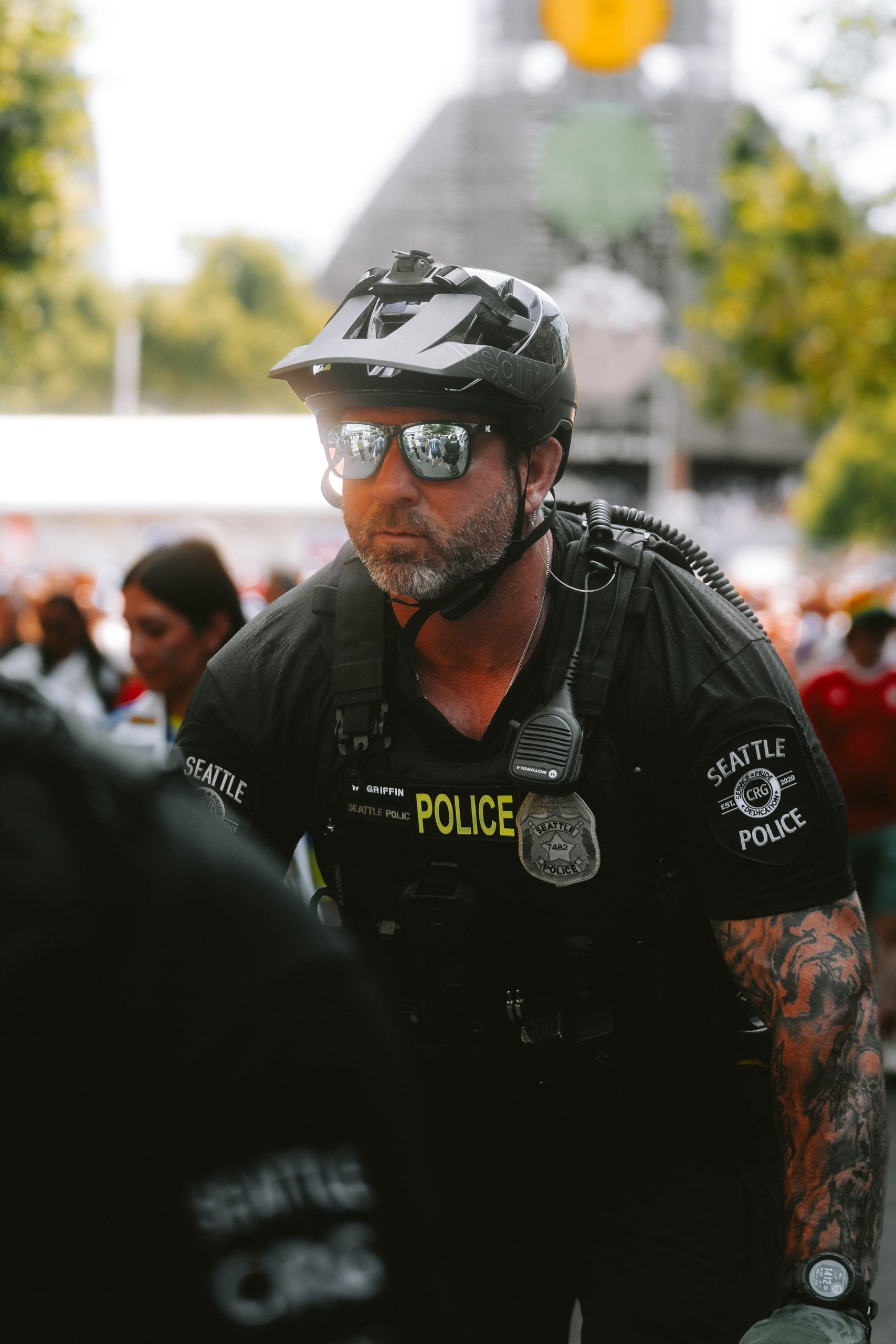 A police officer in sunglasses and helmet among a crowd