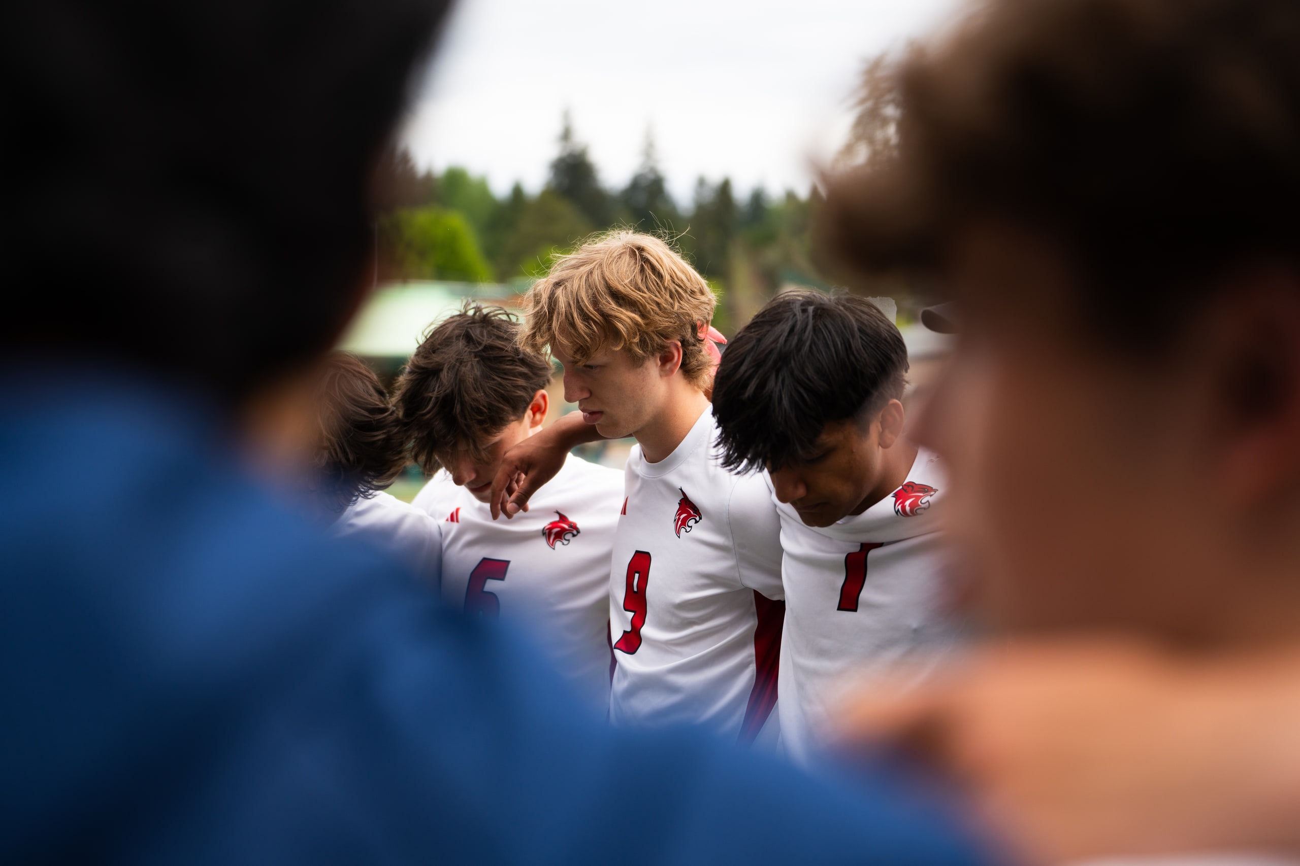 Players leaning together in a huddle before the whistle