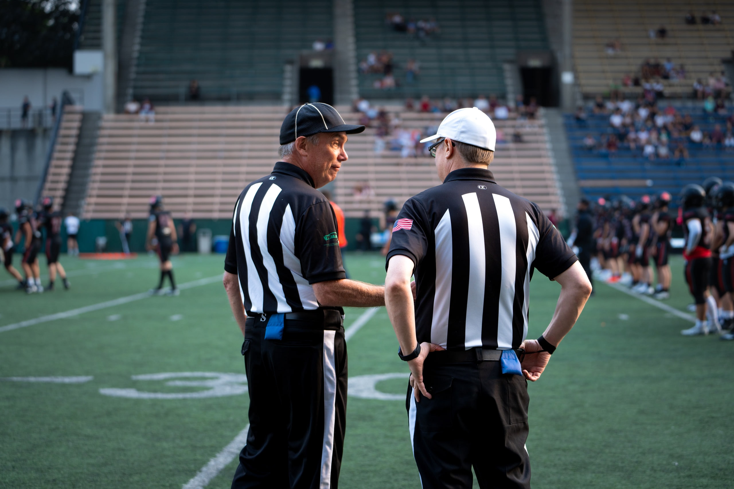 Two officials talking on the sideline before kickoff