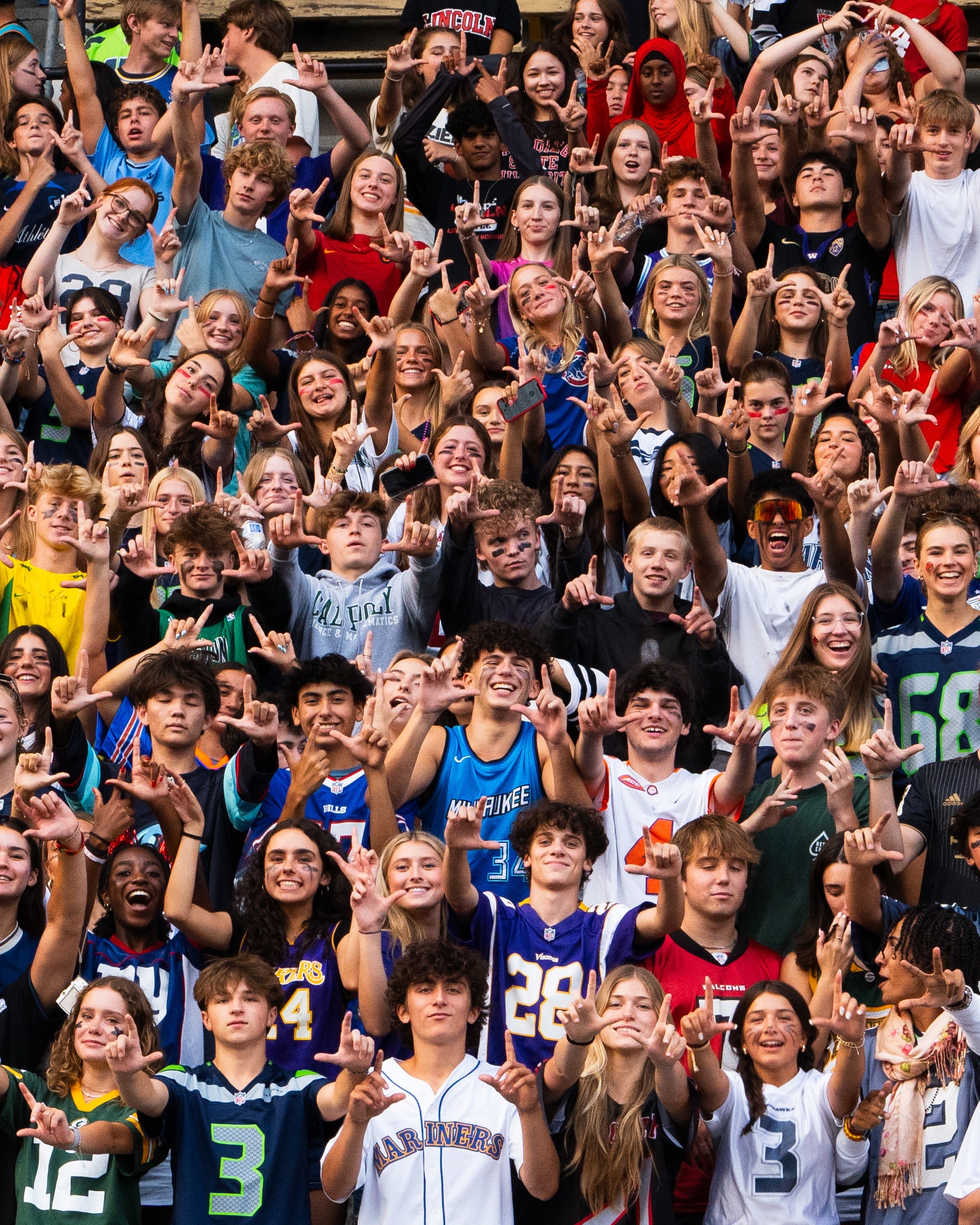 A student section with arms raised mid-chant