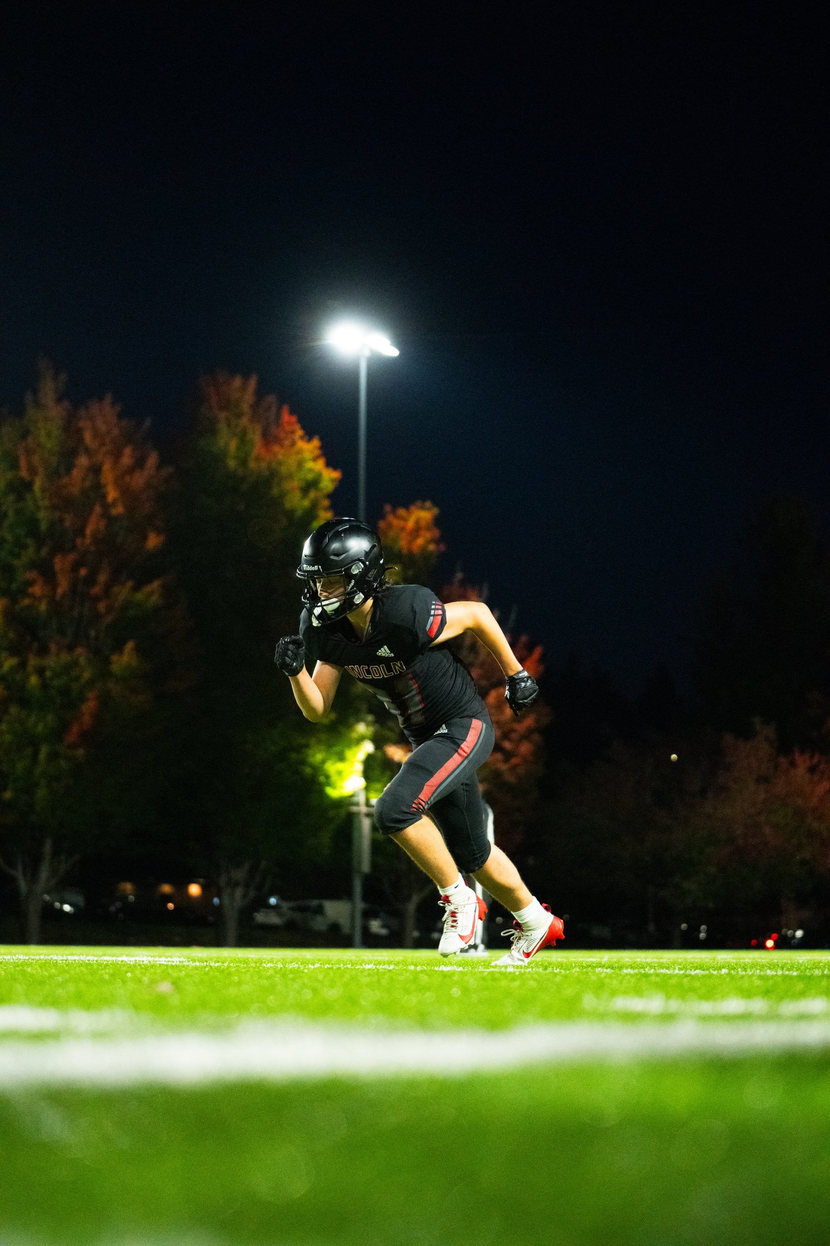 A player alone on the field beneath a stadium light